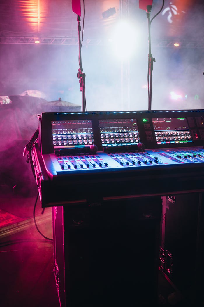 A vibrant shot of a professional audio mixer on a stage under colorful lights, ready for a live performance.